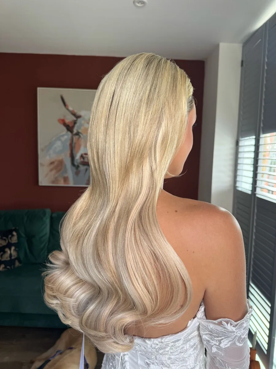 Blonde bride in an off-shoulder gown with long glossy Hollywood waves